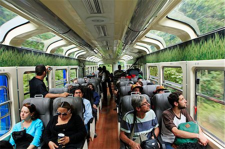 South America, Peru, Cusco, Sacred Valley. Tourists en route to Machu Picchu admire the scenery through panoramic windows of the Vistadome train which runs between Cusco, Poroy, and Machu Picchu via Ollantaytambo Photographie de stock - Rights-Managed, Code: 862-06677368