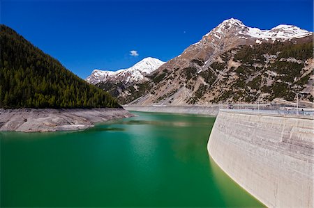 digue - The Punt da Gall  hydroelectric dam on the Swiss / Italian Border with Lago di Livigno with the Piz da l'Acqua Mountain in the background, located in the Il Fuorn National Park, Kanton Graubunden, Switzerland. Photographie de stock - Rights-Managed, Code: 862-06677491