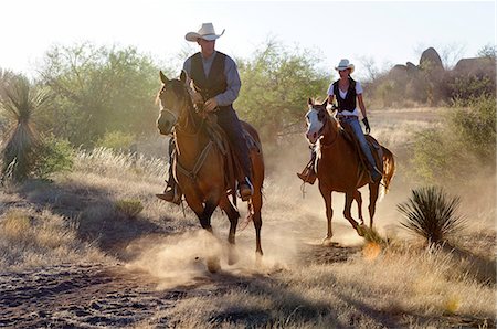 person riding horse - Cowboy and Cowgirl, Apache Spirit Ranch, Tombstone, Arizona, USA Stock Photo - Rights-Managed, Code: 862-06677548