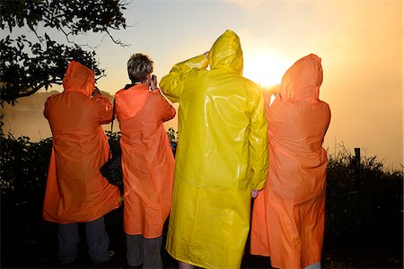 red orange sunset - People with colorful rain coats at Victoria Falls, sunrise, Zambezi River, near Victoria Falls, Zimbabwe, Africa Stock Photo - Rights-Managed, Code: 862-06677644