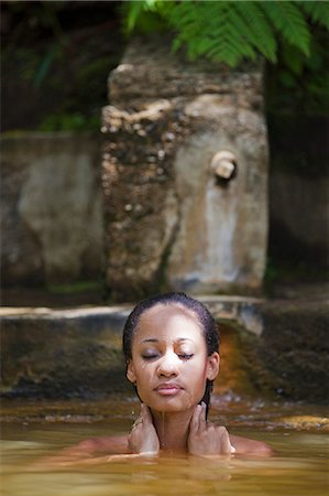 simsearch:862-06825250,k - Dominica, Roseau. A young woman relaxes in the natural springs at Papillote Wilderness Retreat. (MR). Foto de stock - Con derechos protegidos, Código: 862-06825254
