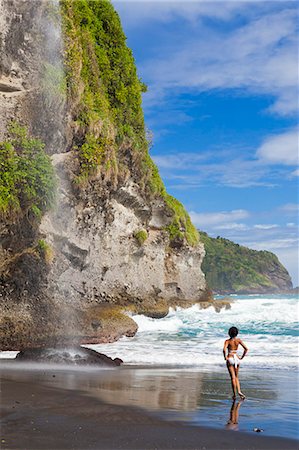 Dominica, Riviere Cyrique. A young woman stands looking at the waterfall at Wavine Cyrique. (MR). Stockbilder - Lizenzpflichtiges, Bildnummer: 862-06825298