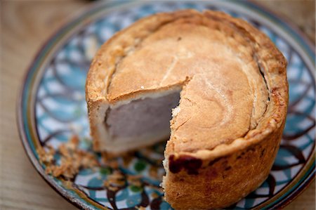 family holiday dining - Nottinghamshire, UK. Melton Mowbray pork pie on handmade ceramic plate. Stock Photo - Rights-Managed, Code: 862-06825326