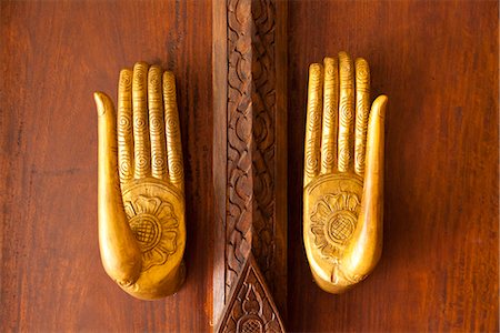 Laos, Luang Prabang. Wooden door handles in the style of Buddha's hands at the Ramayana Hotel. Fotografie stock - Rights-Managed, Codice: 862-06826021