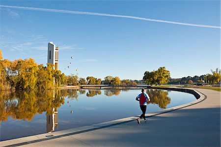 simsearch:862-03736231,k - Australia, Australian Capital Territory (ACT), Canberra.  Man jogging beside Lake Burley Griffin with the National Carillon (belltower) in background. Photographie de stock - Rights-Managed, Code: 862-07495748