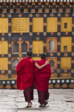 Asia, Paro Dzong, Paro, Bhutan. Young monks enjoying a moment of relaxation and companionship in the courtyard of their Dzong between prayer sessions and classes. Photographie de stock - Rights-Managed, Code: 862-07495777