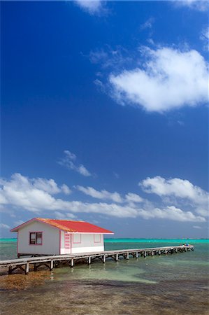 simsearch:862-07495812,k - Central America, Belize, Ambergris Caye, San Pedro, a red hut on a jetty contrasted against the blue sky and turquoise Caribbean sea Stock Photo - Rights-Managed, Code: 862-07495798