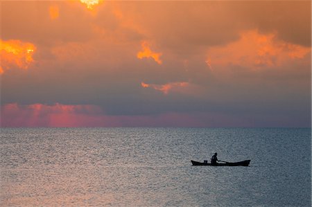 simsearch:862-07495812,k - Central America, Belize, Ambergris Caye, San Pedro, a fisherman in front of stormy clouds at sunset on the Caribbean sea near San Pedro Stock Photo - Rights-Managed, Code: 862-07495799