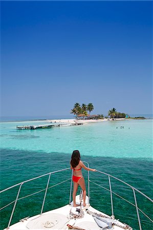 Central America, Belize, Goff's Caye, a model in a bikini looks out from the prow of a motor yacht to Goff's caye - a tiny coral island (MR) Stock Photo - Rights-Managed, Code: 862-07495793