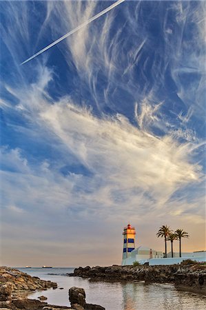 The museum of Farol de Santa Marta Lighthouse at sunset with wispy cloudy formations, Santa Marta, Abuxarda, Lisbon, Lisboa, Portugal. Photographie de stock - Rights-Managed, Code: 862-07496247