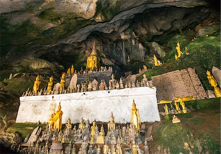 Laos, Pak Ou, Luang Prabang, Luang Prabang Province. Buddha images in the  famous Pak Ou caves which are situated on a limestone cliff overlooking the Mekong River, some 25km from Luang Prabang. Foto de stock - Direito Controlado, Número: 862-07690393
