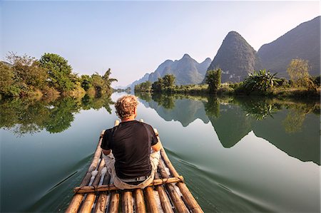 China, Guanxi, Yangshuo. Tourists on bamboo boat on the Li river looking at famous karst peaks (MR) Foto de stock - Con derechos protegidos, Código: 862-07909466