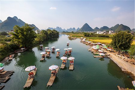 China, Guanxi, Yangshuo. Tourists on bamboo boats on the Li river with famous karst peaks in the background Photographie de stock - Rights-Managed, Code: 862-07909467
