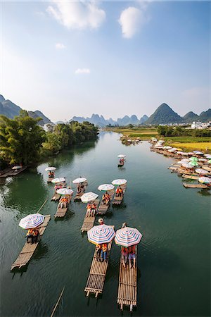river in china - China, Guanxi, Yangshuo. Tourists on bamboo boats on the Li river with famous karst peaks in the background Stock Photo - Rights-Managed, Code: 862-07909468