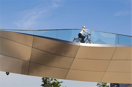 simsearch:862-05997796,k - Young woman biking in front of BMW World, Munich, Bavaria, Germany MR Photographie de stock - Rights-Managed, Code: 862-07909811