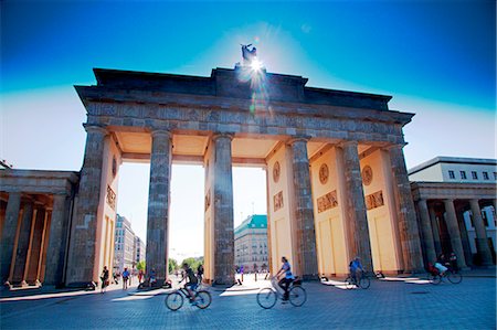 porta di brandeburgo - Germany, Berlin. Cyclists passing under the Brandenburg Gate Fotografie stock - Rights-Managed, Codice: 862-07909848