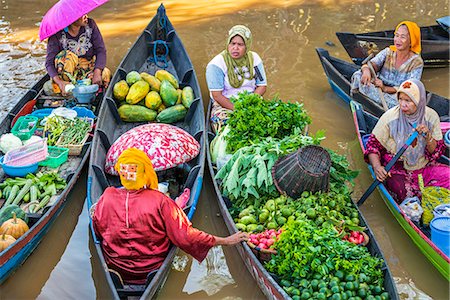 Indonesia, South Kalimatan, Lok Baintan. Market vendors pause to chat at a picturesque floating market on the Barito River. Stock Photo - Rights-Managed, Code: 862-07909924