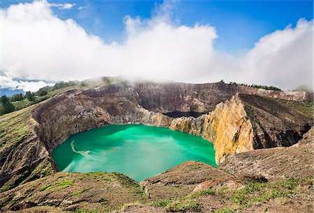 Indonesia, Flores Island, Moni. Low clouds lift to reveal two of the stunning crater lakes of Mount Kelimutu, a dormant volcano which last erupted in 1869. Stock Photo - Rights-Managed, Code: 862-07909981