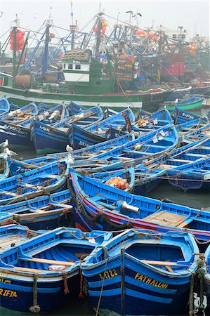 essaouira - Traditional fishing boats in the busy fishing harbour of Essaouira, the third in importance in Morocco. Photographie de stock - Rights-Managed, Code: 862-07910290