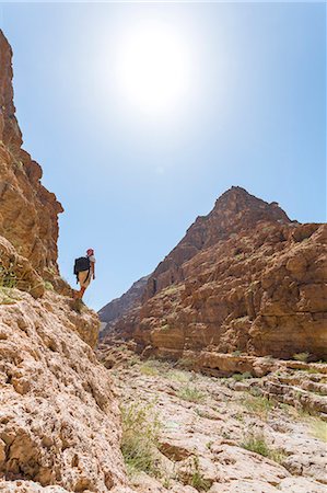 simsearch:862-05999703,k - Oman, Ash Sharqiyah, Tiwi, Wadi Shab. Trekker enjoying the view inside the canyon (MR) Stock Photo - Rights-Managed, Code: 862-07910357