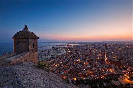 simsearch:862-08090471,k - Sunset view over the cityscape of Alicante looking towards the lookout tower and Port of Alicante from Benacantil Mountain and Santa Barbara Castle in Ensanche Diputacion, Alicante, Valencian Community, Spain. Foto de stock - Con derechos protegidos, Código: 862-07910728