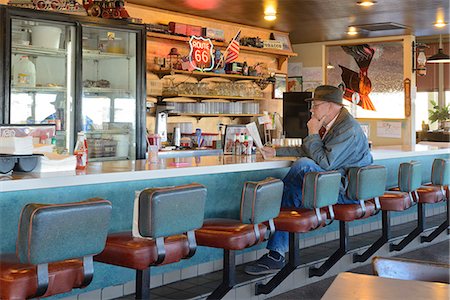 Man with hat reading paper in bar at diner, Route 66, Flagstaff, Arizona, USA  Model release Foto de stock - Con derechos protegidos, Código: 862-07911006