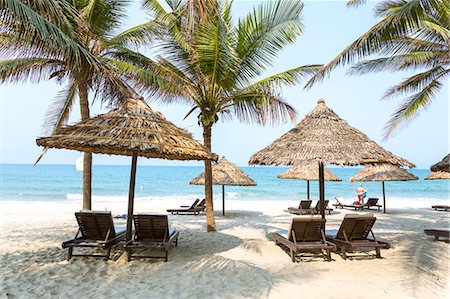 palm tree umbrella - Vietnam, Hoi An. Umbrellas and sunbeds under palm trees at Cua Dai beach Stock Photo - Rights-Managed, Code: 862-07911115