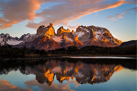 snowy mountain - Chile, Torres del Paine, Magallanes Province. Sunrise over Torres del Paine reflected in the waters of Lake Pehoe in the foreground. One of the principal attractions of the National Park is the magnificent Paine massif. Stock Photo - Rights-Managed, Code: 862-08090054