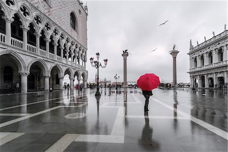 simsearch:851-02960894,k - Italy, Veneto, Venice. Woman with red umbrella in front of Doges palace with acqua alta (MR) Stock Photo - Rights-Managed, Code: 862-08090399