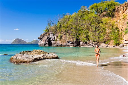 Dominica, St John Parish, Portsmouth, Secret Bay. A young lady runs along Secret Beach.. Photographie de stock - Rights-Managed, Code: 862-08272985