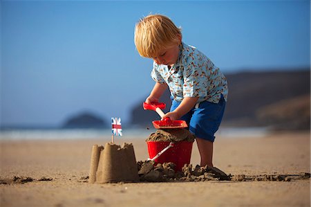 simsearch:6109-06003778,k - UK, Cornwall, Polzeath. A young boy puts the finishing touches to his sand castle. Photographie de stock - Rights-Managed, Code: 862-08273025