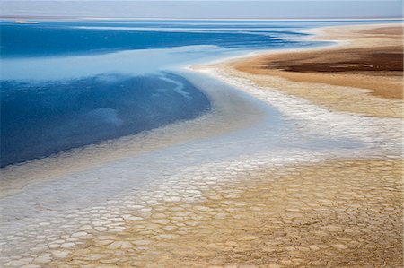 Ethiopia, Lake Karum, Afar Region. Lake Karum is a saline lake which lies 116 metres below sea level beside the Assale salt flats where salt is mined.  Note the salt patterns beside the lakeshore. Stock Photo - Rights-Managed, Code: 862-08273072