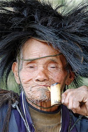 simsearch:862-03807589,k - India, Arunachal Pradesh, Ziro Valley, near New Ziro. At Lempia a pipe smoking, rain hat wearing villager belonging to the Apatani tribe participates in traditional shamanic rituals. Stock Photo - Rights-Managed, Code: 862-08273301
