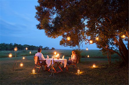 safari - Kenya, Mara North Conservancy. A couple enjoy a romantic dinner overlooking the Mara. Foto de stock - Con derechos protegidos, Código: 862-08273553