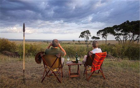 Kenya, Mara North Conservancy. A couple enjoy a sundowner in the Mara North Conservancy. Foto de stock - Con derechos protegidos, Código: 862-08273577