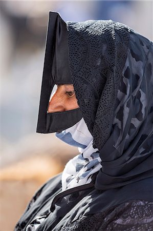 Oman, Ad Dakhiliyah Governorate, Nizwa. A black masked woman at the lively livestock market at Nizwa where local farmers sell goats and cattle. These masks usually denote a woman s Bedouin heritage. Stock Photo - Rights-Managed, Code: 862-08273750