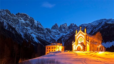 Europe, Italy, Veneto. The parish church of Falcade in the late evening with behind the towers of Focobon.  Agordino, Dolomites Stockbilder - Lizenzpflichtiges, Bildnummer: 862-08698832