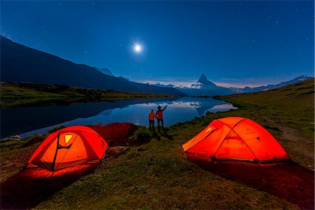 simsearch:862-08698906,k - Mount Matterhorn, Stellisee, Zermatt, Switzerland.  Two hikers observe the Matterhorn mountain in the moonlight. Behind them two tents Ferrino lit Photographie de stock - Rights-Managed, Code: 862-08698906