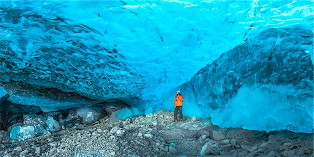 Skaftafell national park, Iceland, Europe. Man with colored jacket in a blue crystal ice cave under the Vatnajokull glacier in winter. Photographie de stock - Rights-Managed, Code: 862-08699327