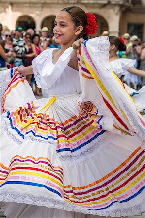 Cuba, Havana, Plaza de Armas, Habana Vieja.  A young girl participates in a public dancing display at Plaza de Armas, Havanas oldest square which was laid out in the 1520s. Foto de stock - Con derechos protegidos, Código: 862-08704777