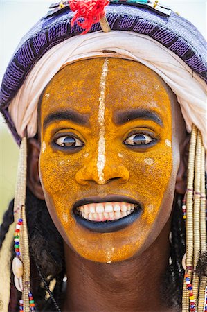 scusarsi - Niger, Agadez, Inebeizguine. A young Wodaabe man in traditional embroidered garments participates in the yakee dance known as the Dance of the Eyes. Fotografie stock - Rights-Managed, Codice: 862-08704943
