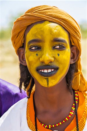 Niger, Agadez, Inebeizguine. A young Wodaabe man with a painted face during a Gerewol ceremony. Photographie de stock - Rights-Managed, Code: 862-08704954