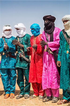 simsearch:862-08704968,k - Niger, Agadez, Inebeizguine. Wodaabe men in colourful attire watch the young men of the tribe dance during a Gerewol ceremony. Photographie de stock - Rights-Managed, Code: 862-08704950