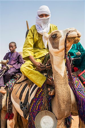 Niger, Agadez, Dabous. A Tuareg young man rides his favourite camel which has unusual markings. Photographie de stock - Rights-Managed, Code: 862-08704964