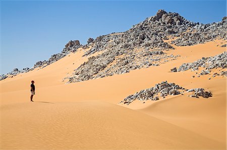 simsearch:862-03820902,k - Niger, Agadez, Sahara Desert, Tenere, Blue Mountains. A visitor admires the outcrops of blue marble in the middle of Tenere desert. Fotografie stock - Rights-Managed, Codice: 862-08704982