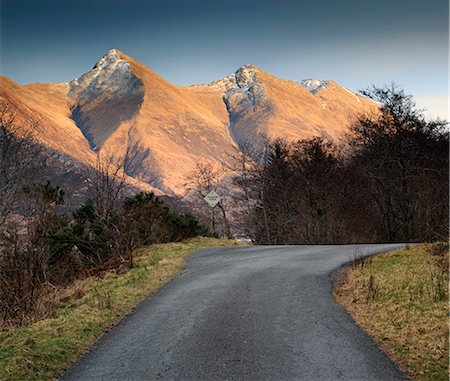 simsearch:862-08699903,k - Scotland, Highland. A small road in the Highlands with evening sunlight on the Five Sisters of Kintail. Stockbilder - Lizenzpflichtiges, Bildnummer: 862-08700010