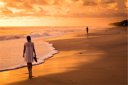 paradise palm - Playa Santa Teresa at sunset, Mal Pais, Costa Rica. Young girl looking at the ocean on the beach. Stock Photo - Rights-Managed, Code: 862-08718529