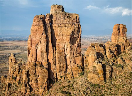 pinnacles (rock formation) - Ethiopia, Tigray Region, Gheralta Mountains, Guh. The priest at the important ancient rock-hewn of Abune Yemata can be seen at the entrance to his church half way up the stunning Guh feature in the Gheralta Mountains. Stock Photo - Rights-Managed, Code: 862-08718812