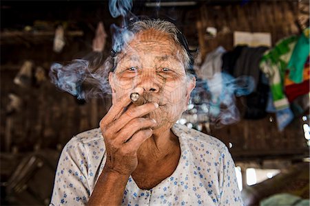 Rakhine state, Myanmar. Chin woman with traditional tattooed face smoking. Stock Photo - Rights-Managed, Code: 862-08719274