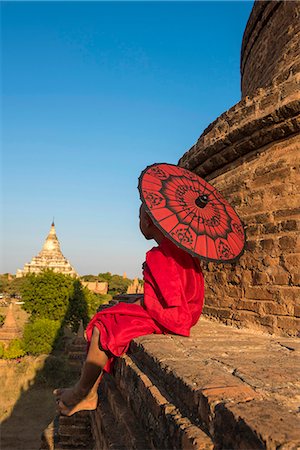 simsearch:6129-09057891,k - Bagan, Mandalay region, Myanmar (Burma). A young monk with red umbrella watching the Shwesandaw pagoda in a distance. Stock Photo - Rights-Managed, Code: 862-08719293